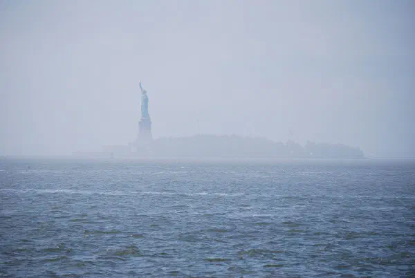 The Statue of Liberty in the mist seen from Battery Park